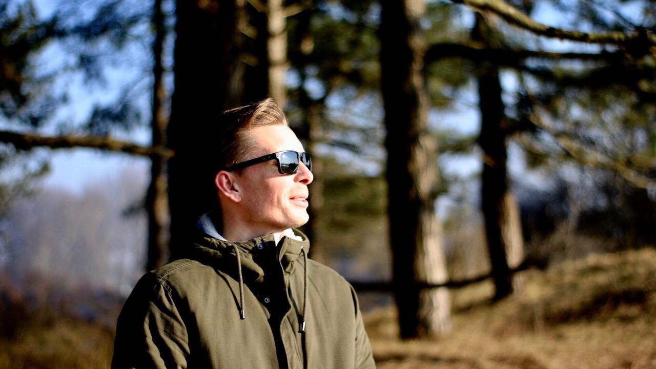 Man wearing sunglasses against trees