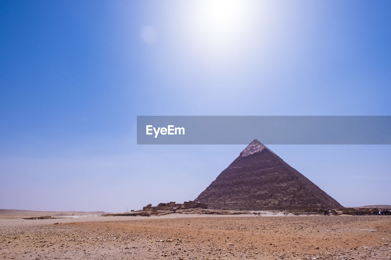 Pyramid at desert against clear sky on sunny day