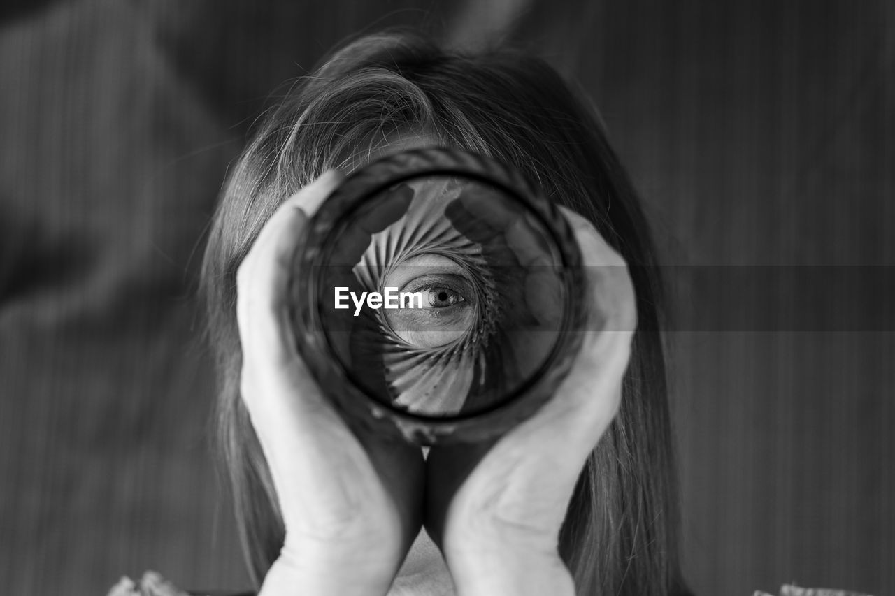 Close-up portrait of woman looking through glass