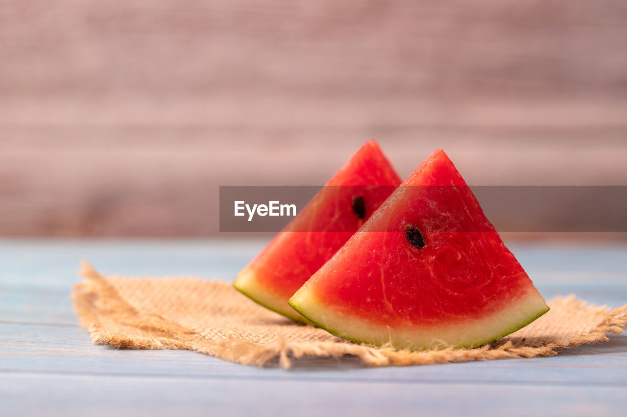 food and drink, watermelon, food, fruit, melon, healthy eating, plant, produce, freshness, wellbeing, slice, wood, no people, red, copy space, close-up, nature, studio shot, focus on foreground, sweet food, table
