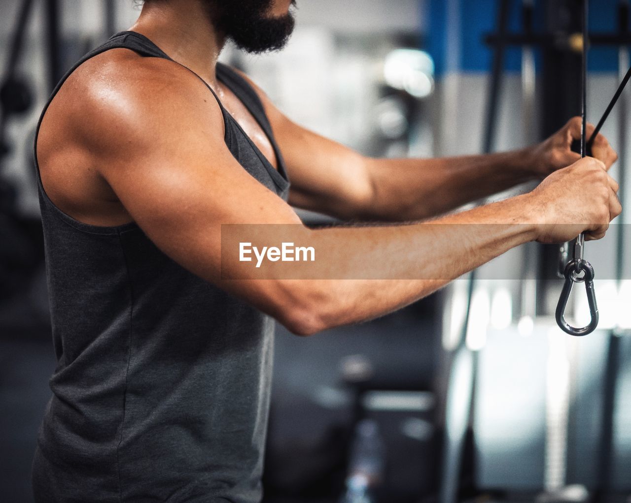 Midsection of young man exercising in gym