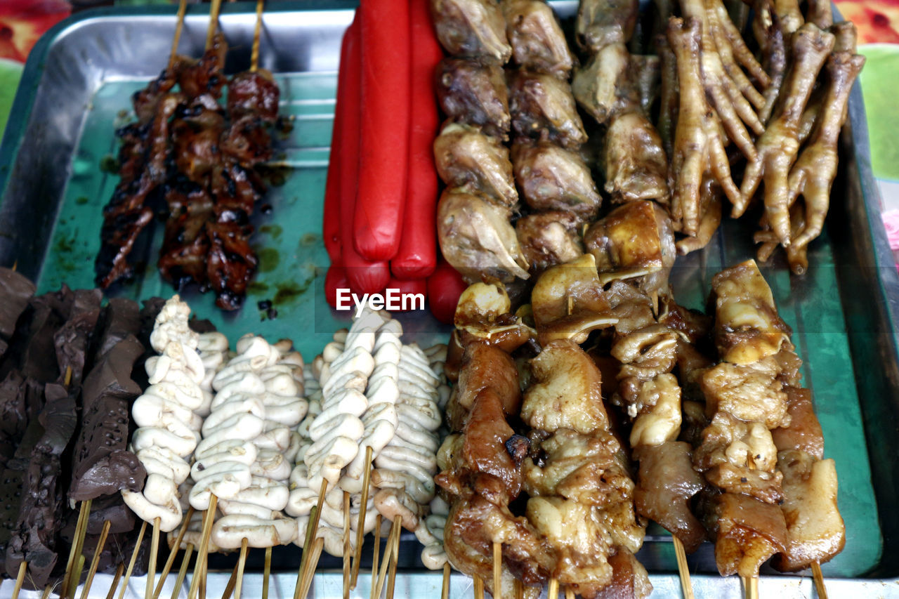 Assorted chicken and pork innards and hotdog in barbecue sticks sold as street food