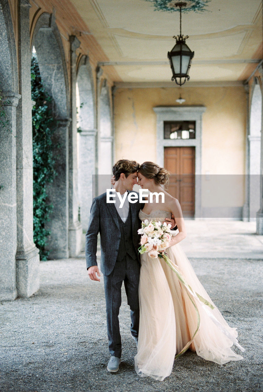 portrait of bride and groom standing in building