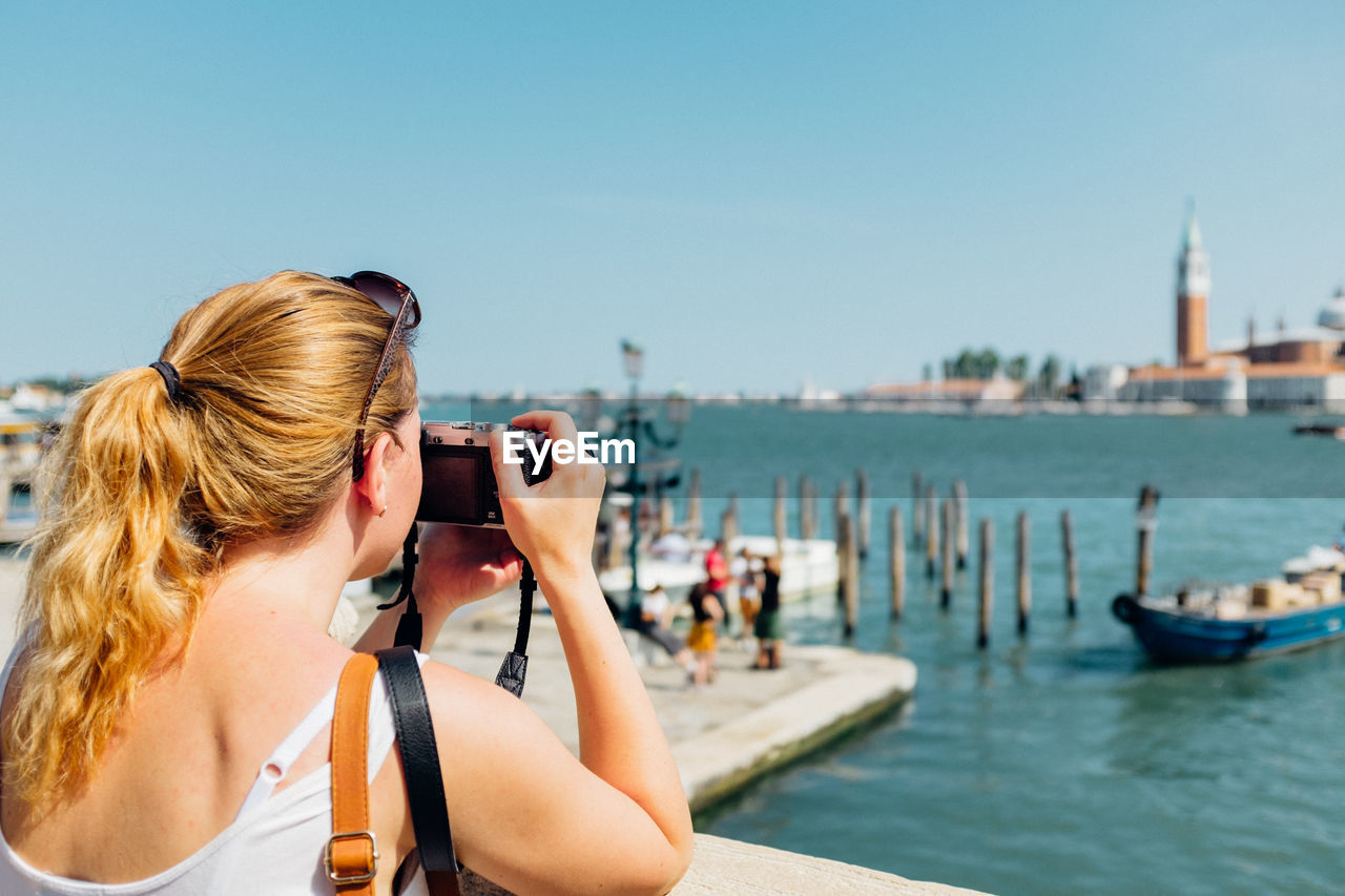 Woman photographing in harbor