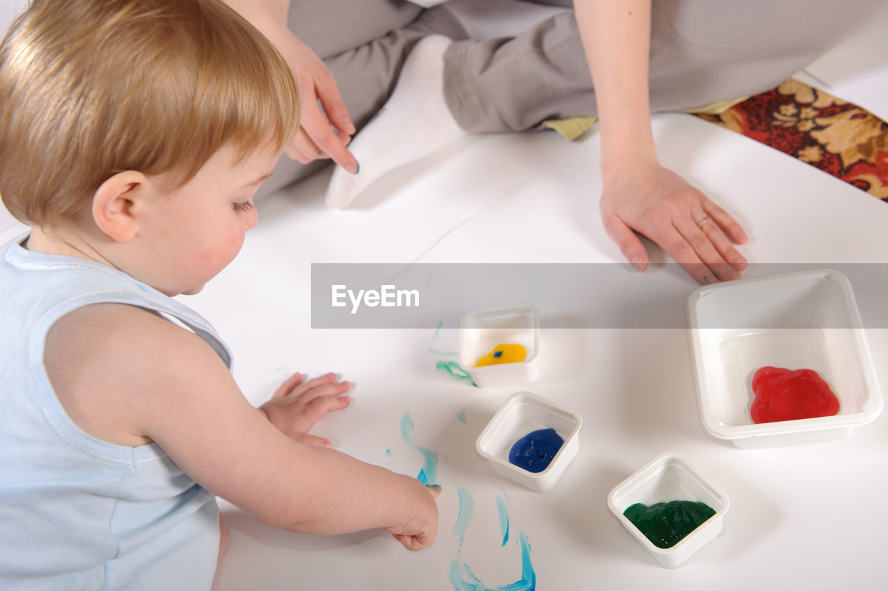 High angle view of girl with brother painting on paper