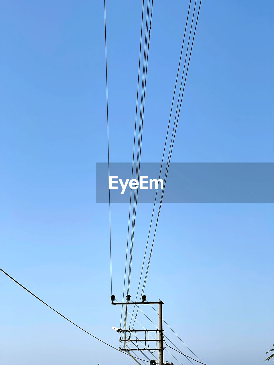 cable, electricity, sky, technology, overhead power line, power supply, blue, power generation, power line, electricity pylon, nature, clear sky, line, tower, no people, transmission tower, low angle view, electrical supply, mast, day, outdoors, telephone line, transportation, copy space, outdoor structure, sunny