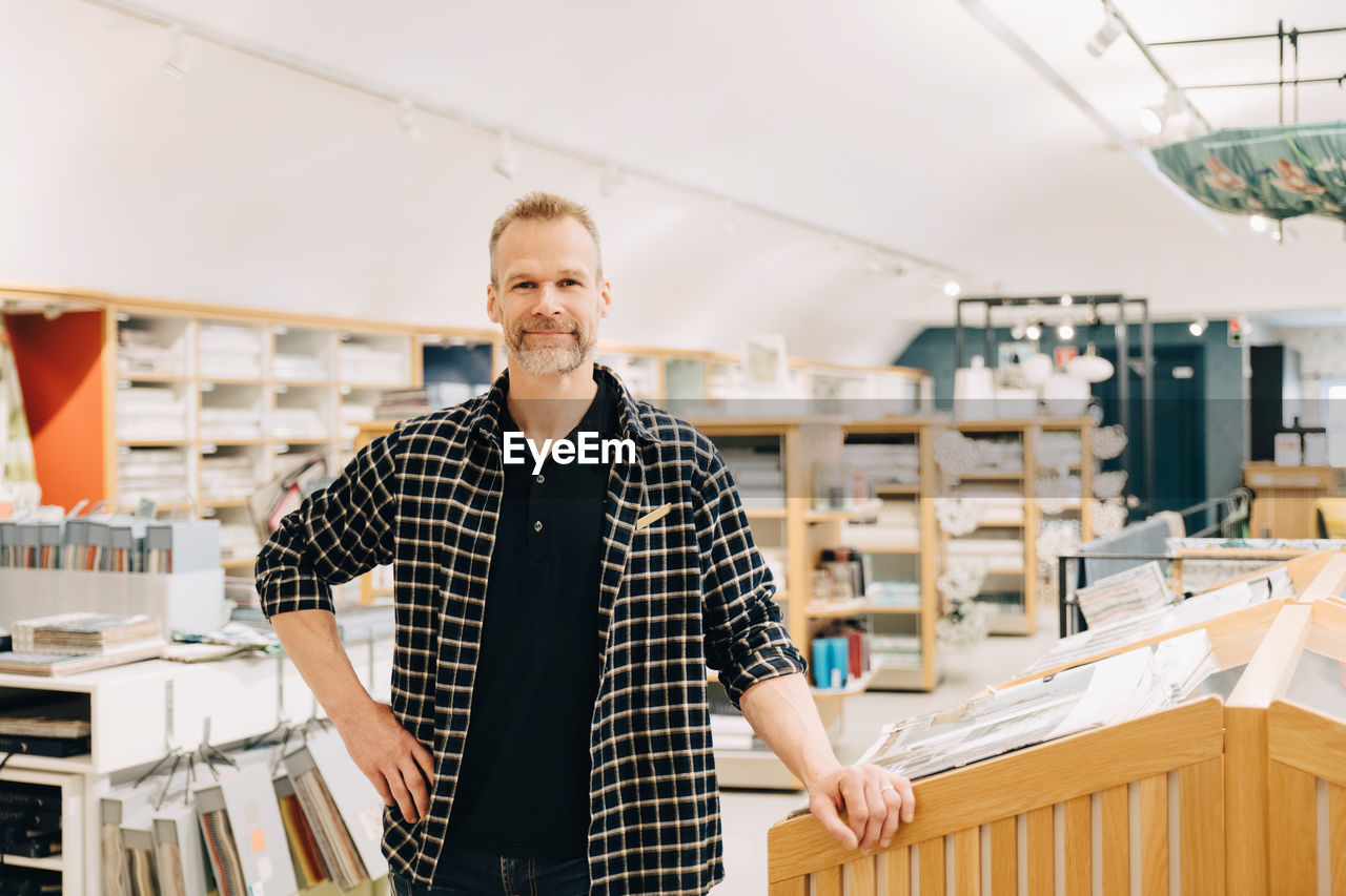 Portrait of smiling salesman standing in store