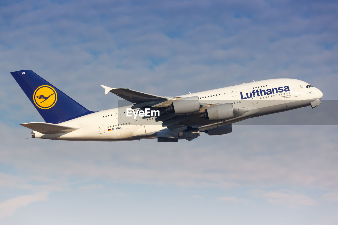 LOW ANGLE VIEW OF AIRPLANE FLYING AGAINST BLUE SKY