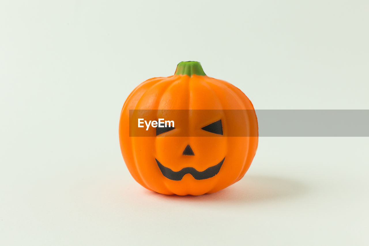 CLOSE-UP OF PUMPKIN ON ORANGE BACKGROUND