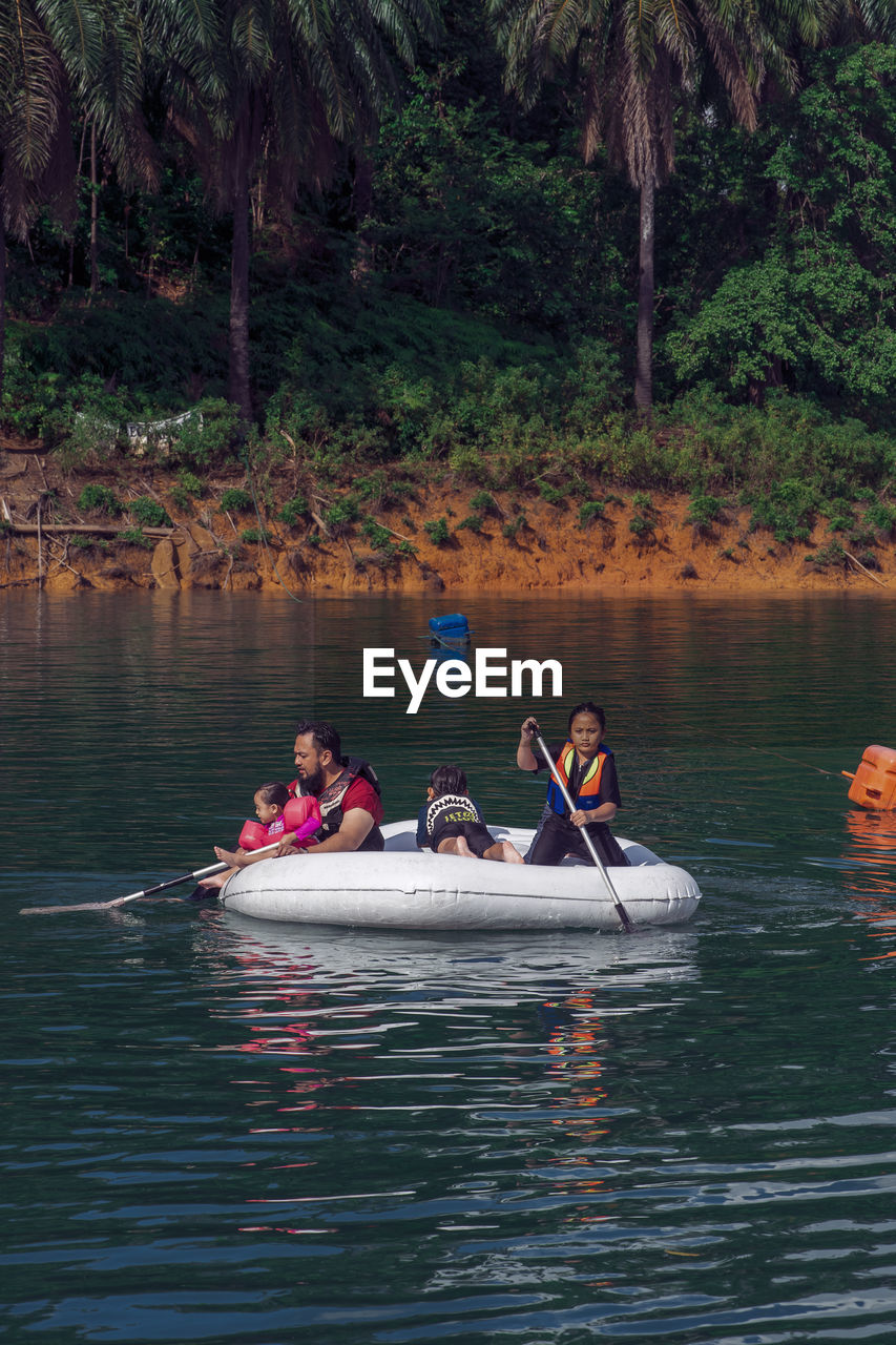 PEOPLE IN BOAT AGAINST LAKE