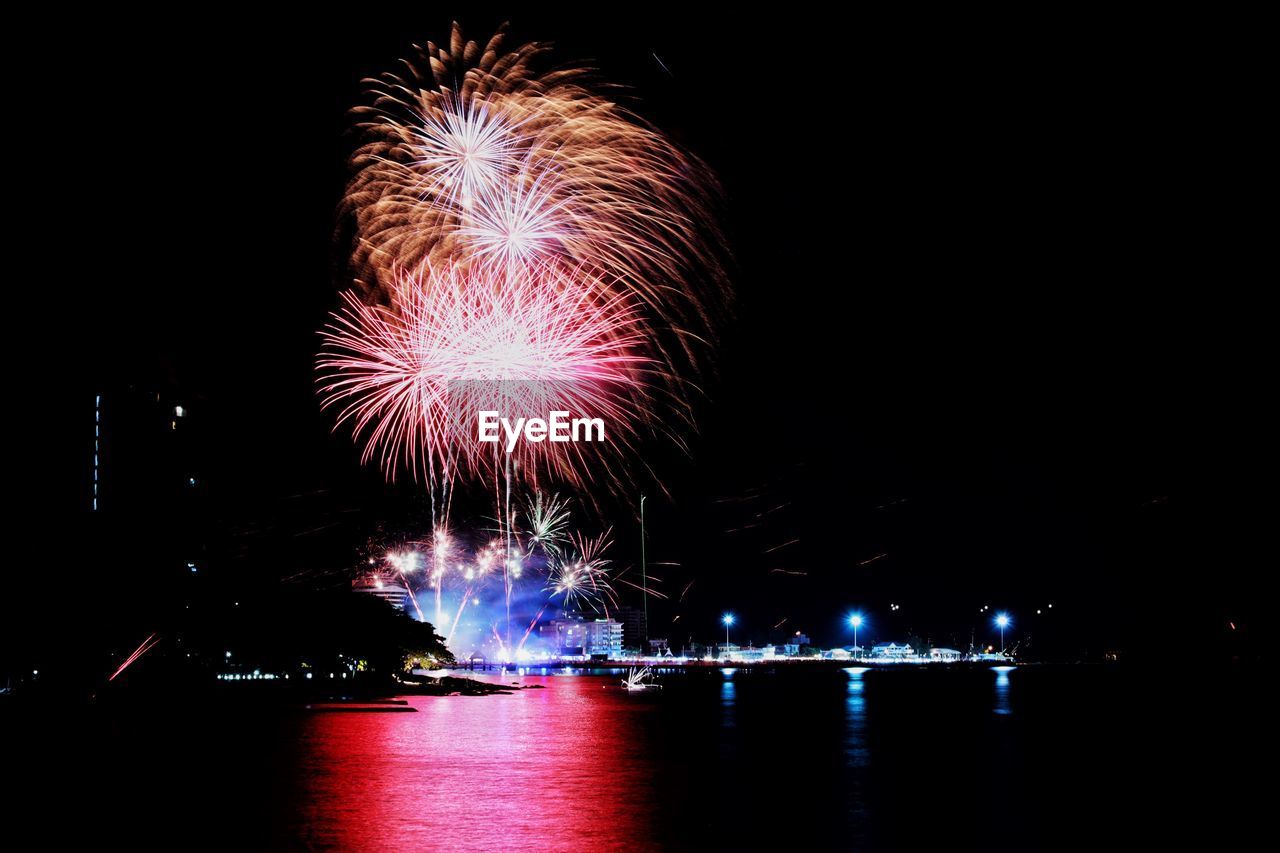 FIREWORK DISPLAY OVER RIVER AGAINST SKY