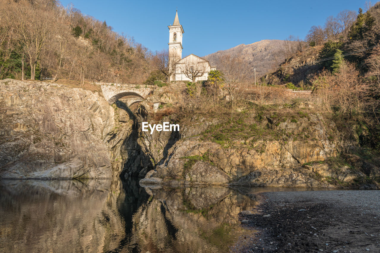 The beautiful ravine of sant'anna with the church reflected in the water of the river