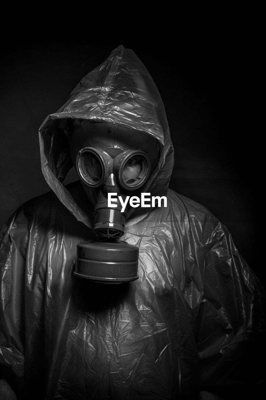 Man wearing gas mask against black background