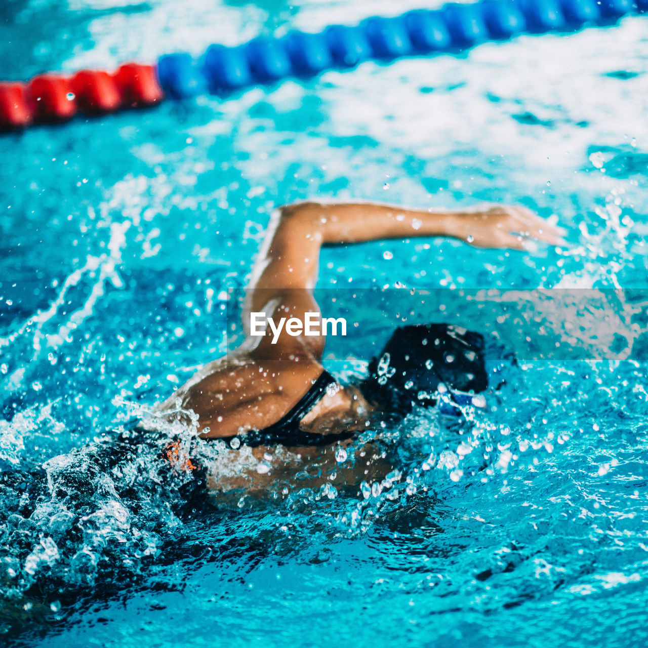 Rear view of woman swimming in pool during competition
