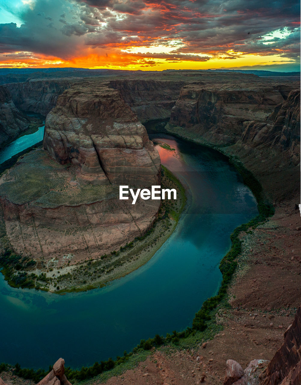 Scenic view of horseshoe bend against sky during sunset