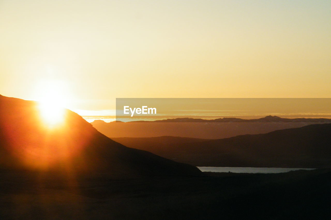 Scenic view of silhouette mountains against sky during sunset