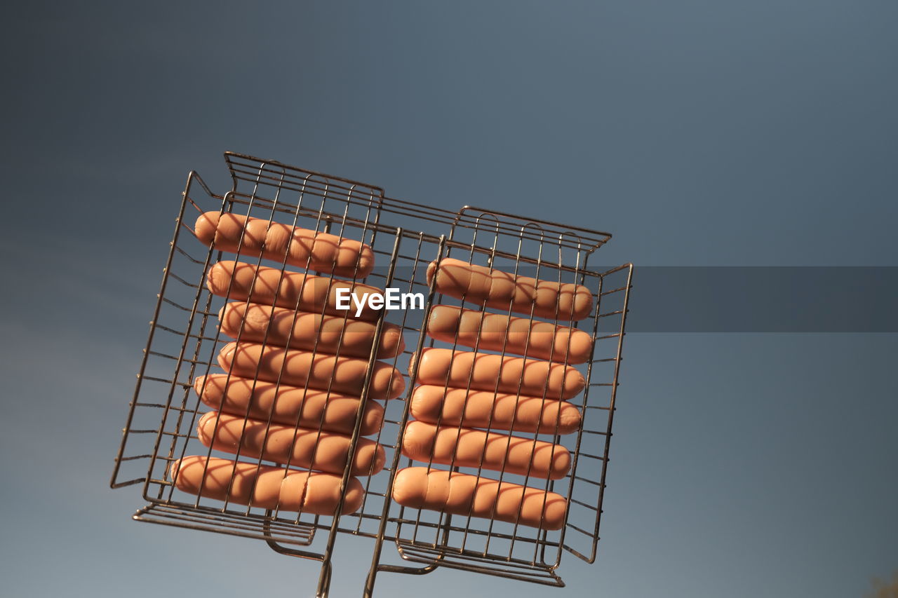 LOW ANGLE VIEW OF BARBECUE GRILL AGAINST SKY OVER BACKGROUND