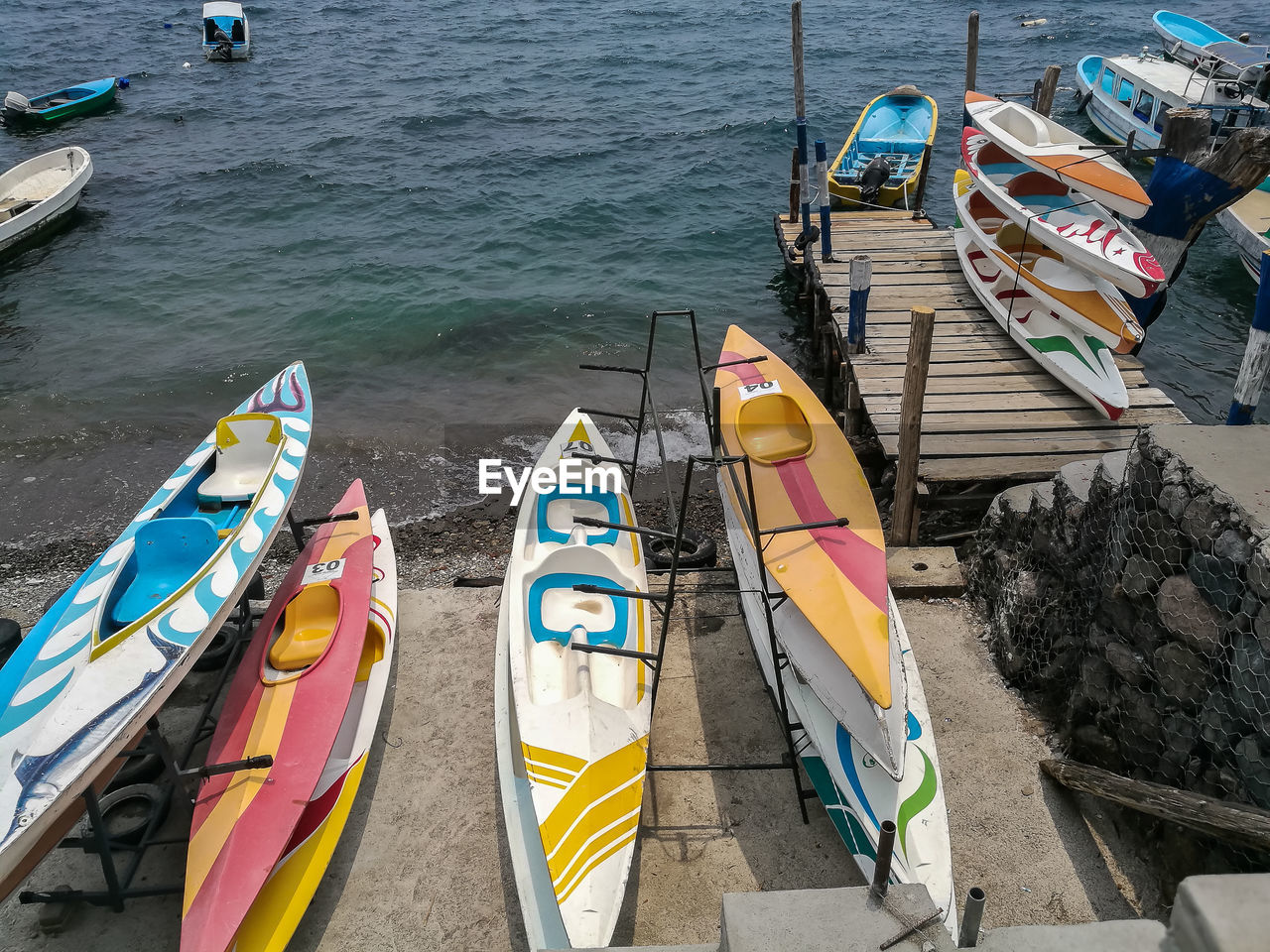 HIGH ANGLE VIEW OF MULTI COLORED MOORED BOATS IN SEA