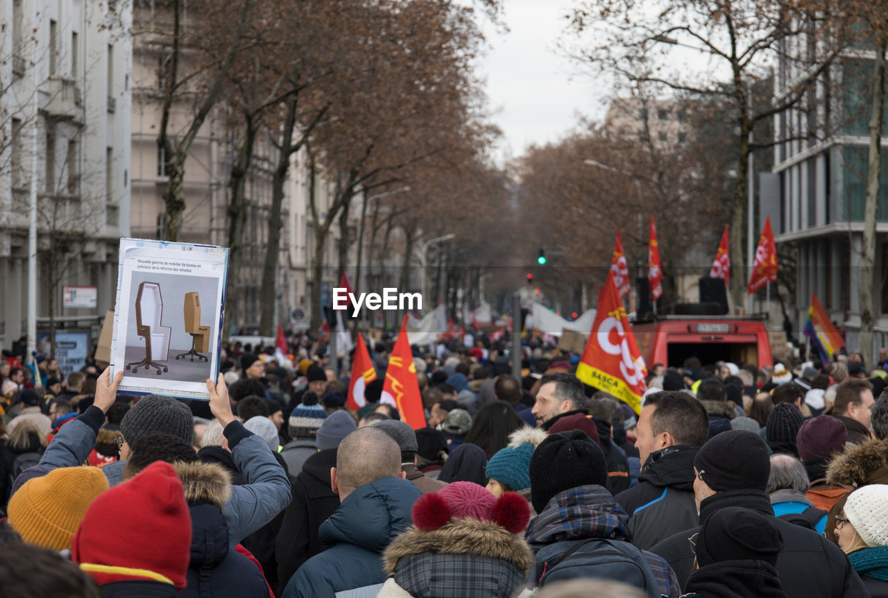 crowd, group of people, large group of people, protest, architecture, city, flag, tree, building exterior, women, men, adult, street, person, protestor, built structure, outdoors, plant, nature, day, clothing, education, law, unity