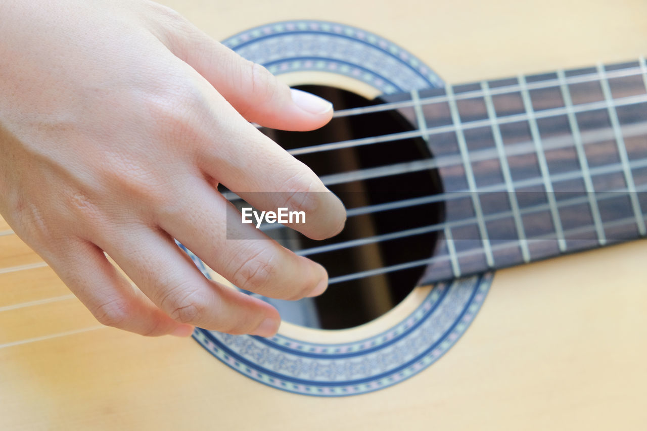 Cropped hand of person playing guitar