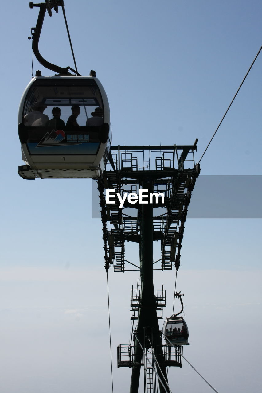 Low angle view of overhead cable car against sky