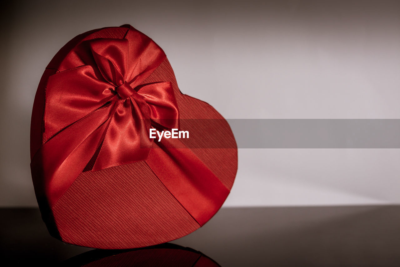 Close-up of red heart shaped gift on table