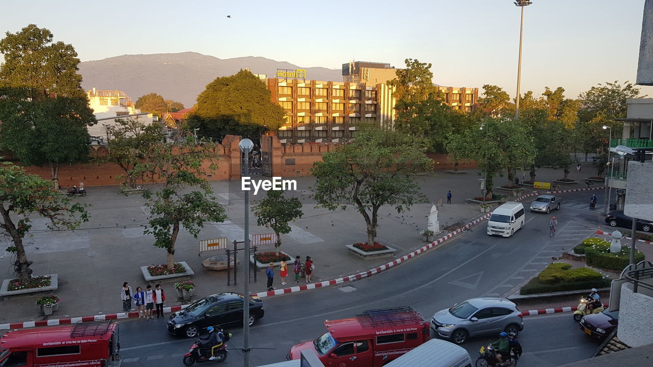 VEHICLES ON ROAD IN CITY AGAINST SKY