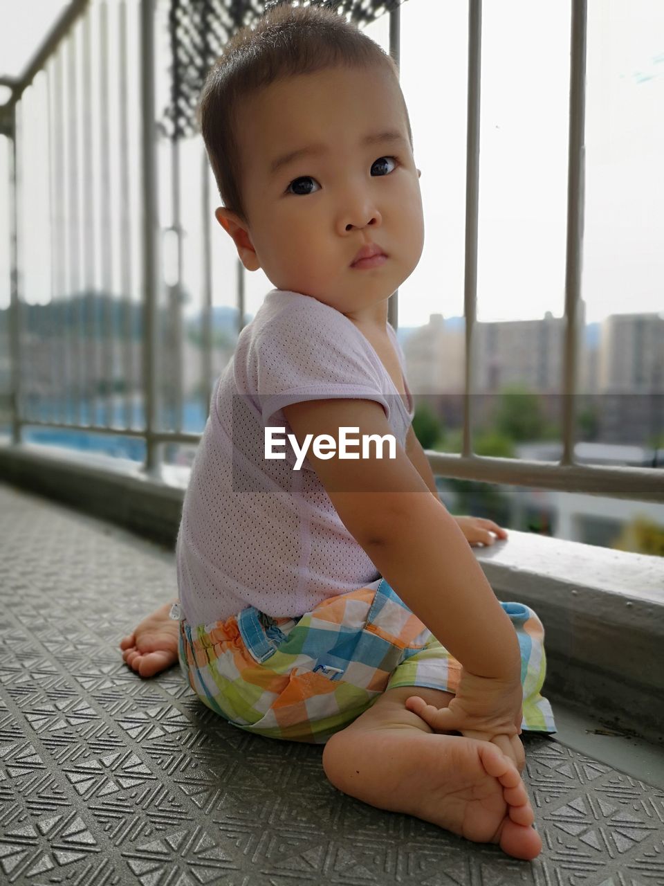 Portrait of cute baby boy sitting in balcony