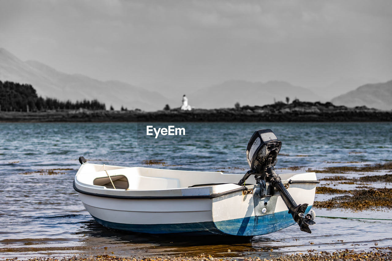 BOAT MOORED ON SEA AGAINST SKY