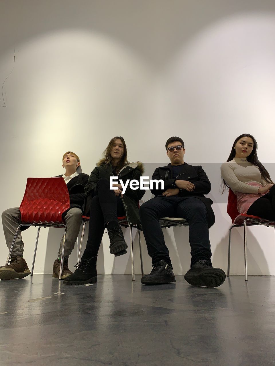 FULL LENGTH OF FRIENDS SITTING ON CHAIR IN BUILDING