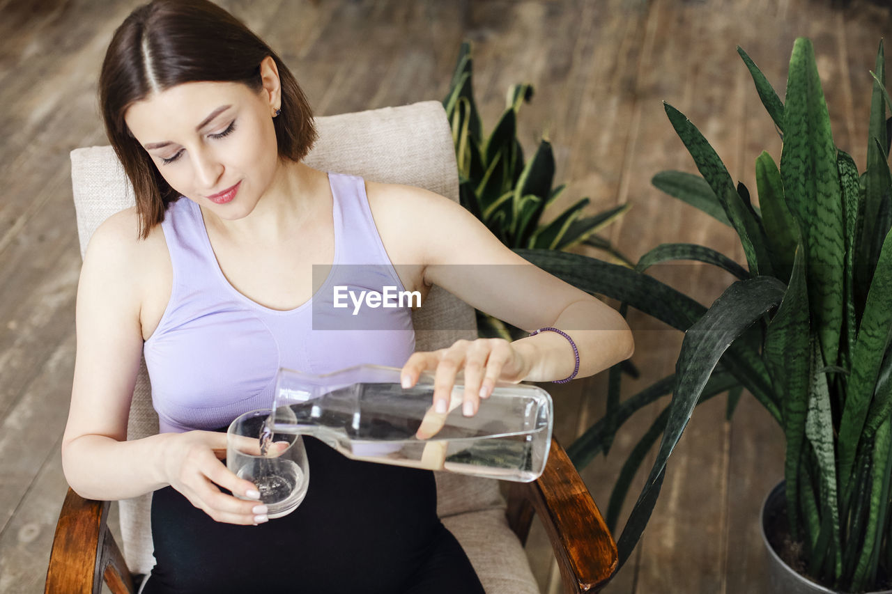 portrait of smiling young woman holding drink in glass