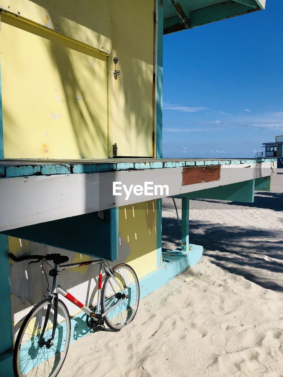 BICYCLE ON BEACH AGAINST SKY