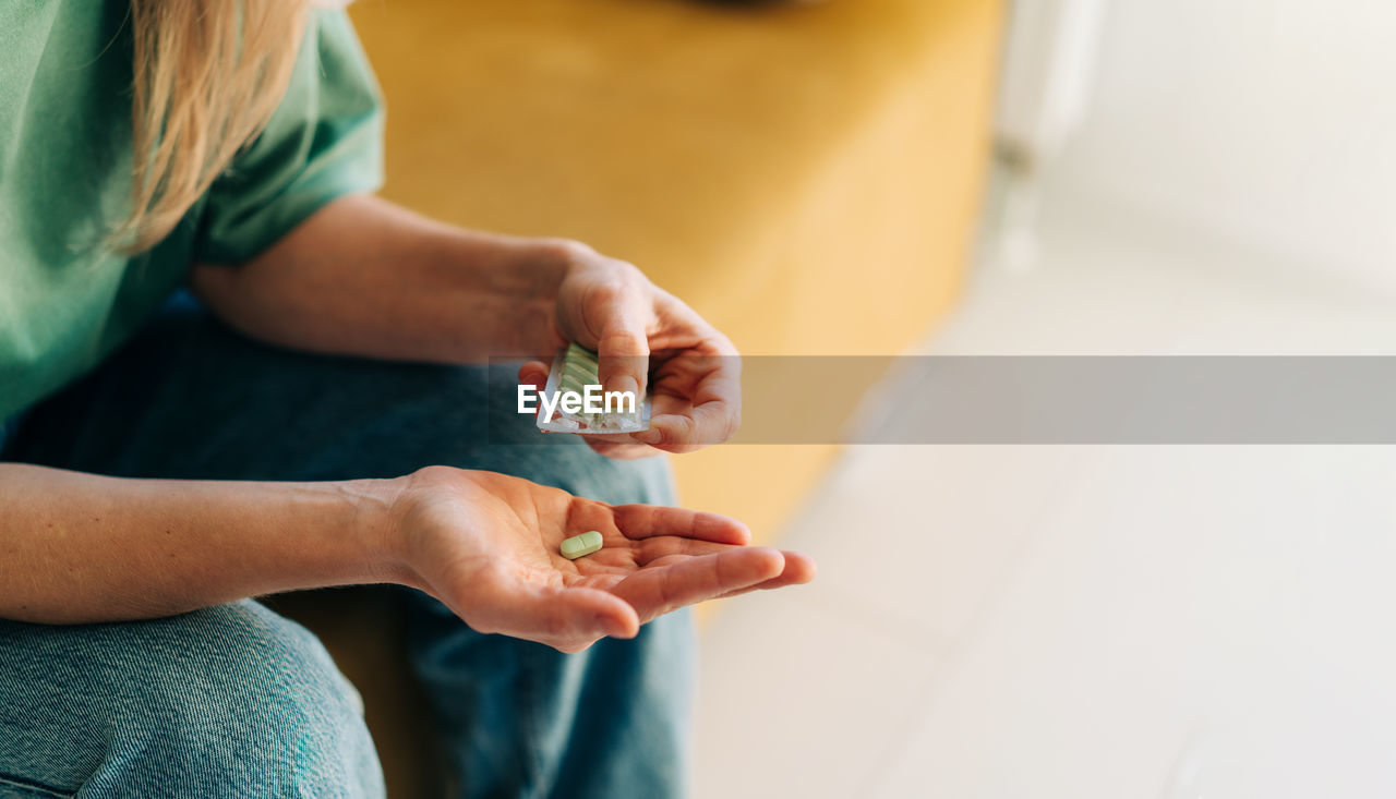 Close-up of a woman holding pills. copy space