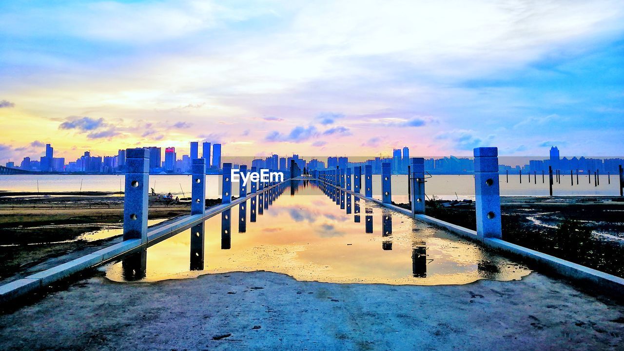 Scenic view of city against sky during sunset