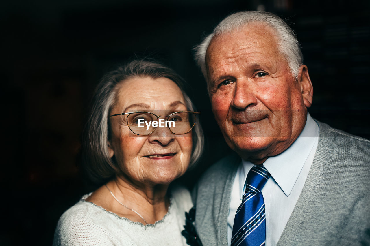Close-up portrait of senior couple smiling in darkroom