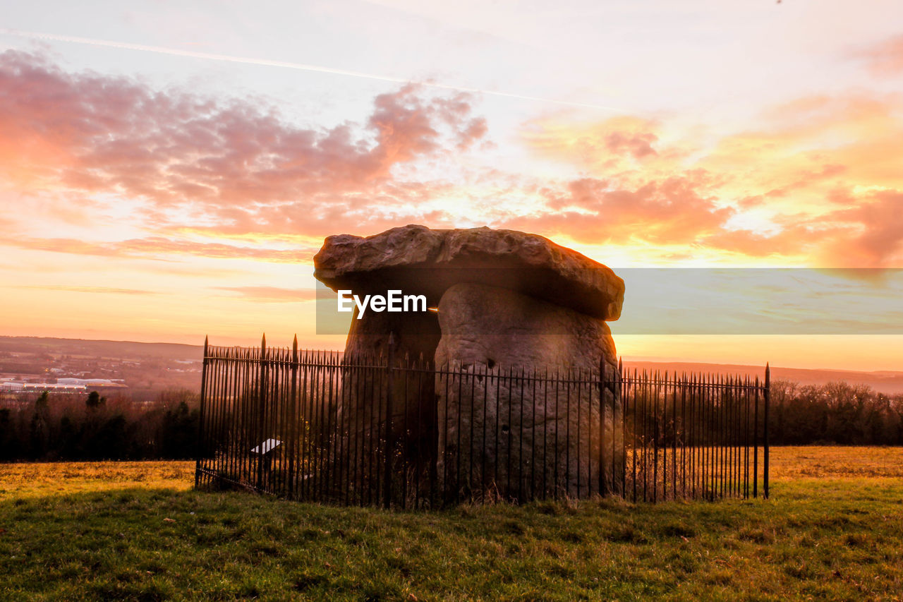 Burial chamber on field against sky during sunset