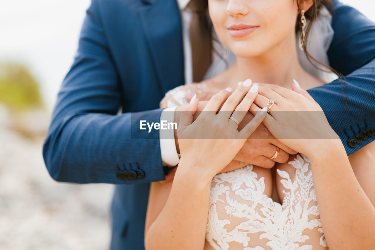 Midsection of couple embracing outdoors