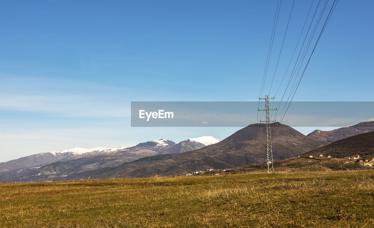 Scenic view of mountains against blue sky