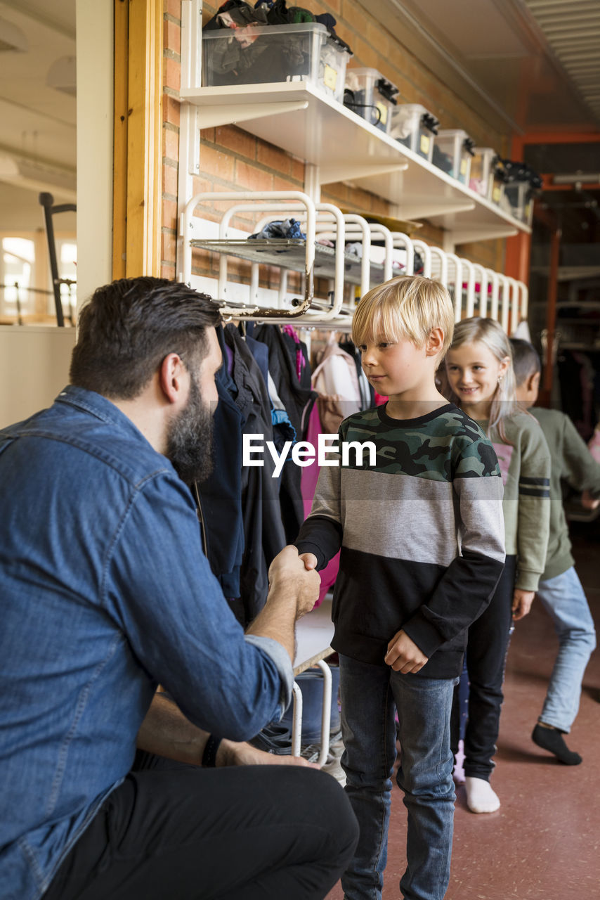 Teacher greeting children