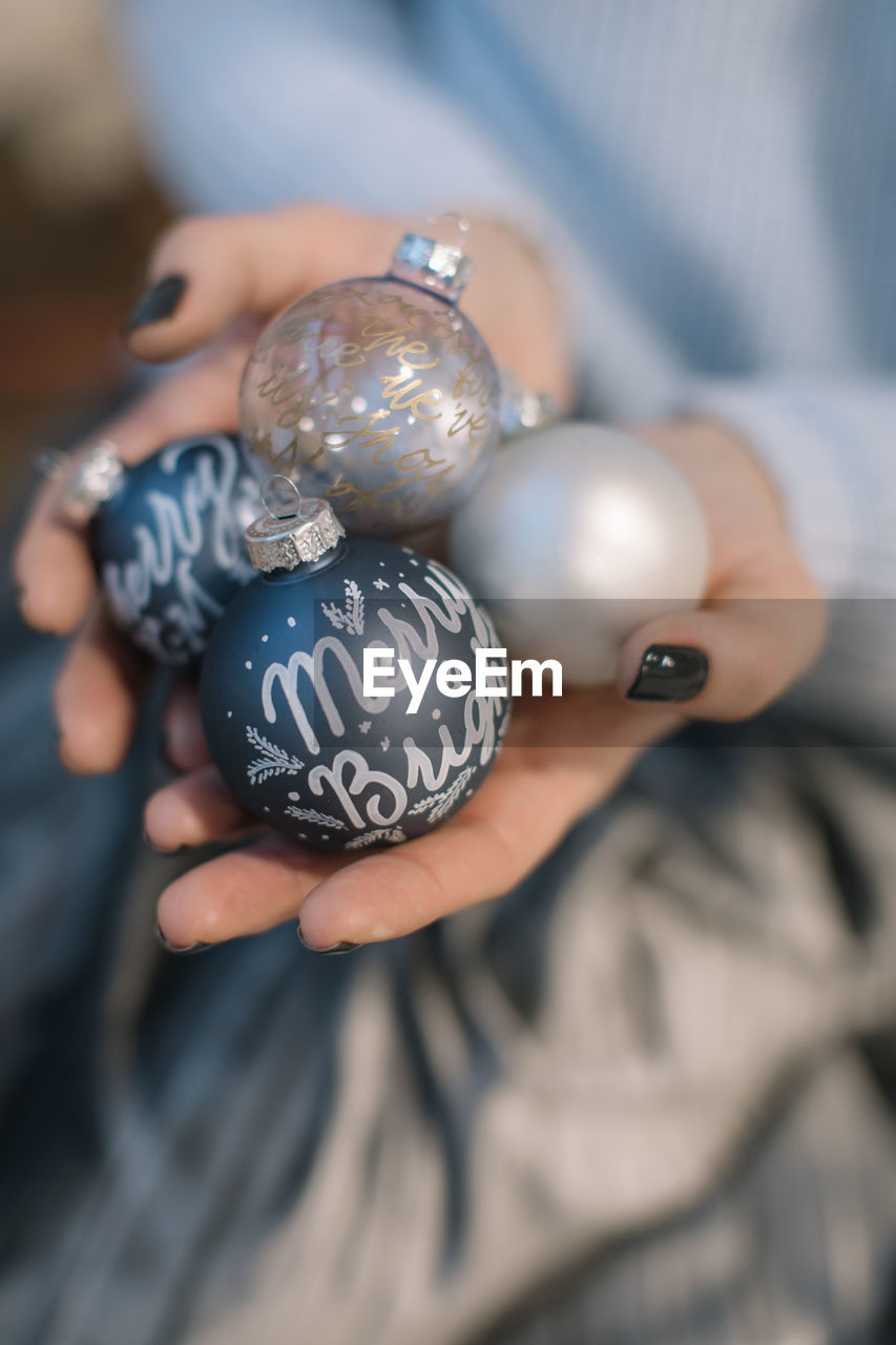 Midsection of woman holding christmas ornaments