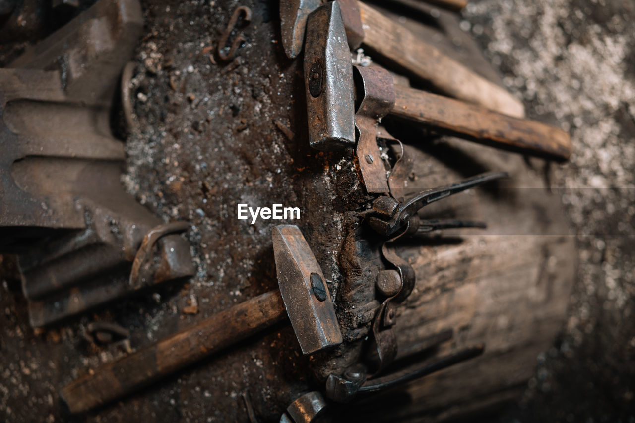 High angle view of old rusty metal hammer and blacksmith tools 