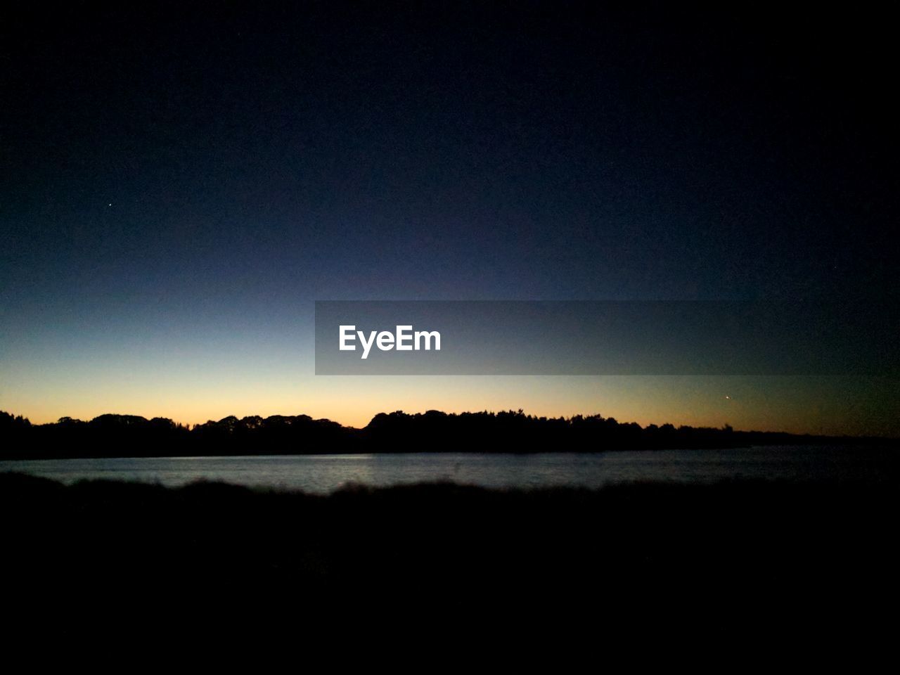 SCENIC VIEW OF LAKE AGAINST CLEAR SKY AT NIGHT