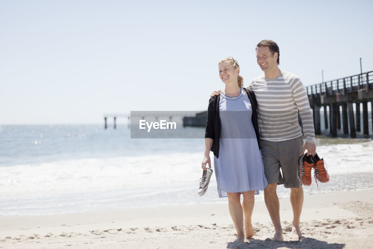 Smiling couple walking on beach