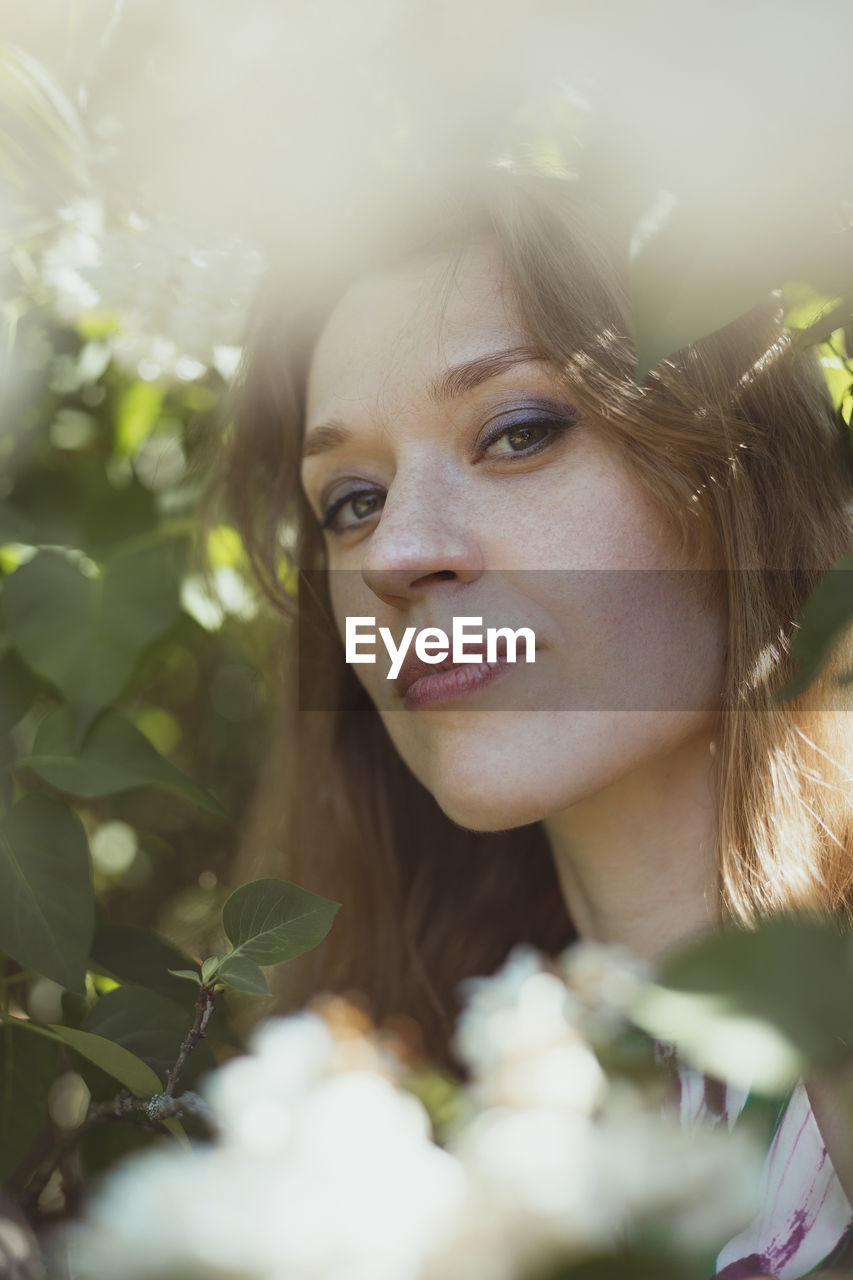 Close up woman with bright makeup surrounded by white flowers portrait picture