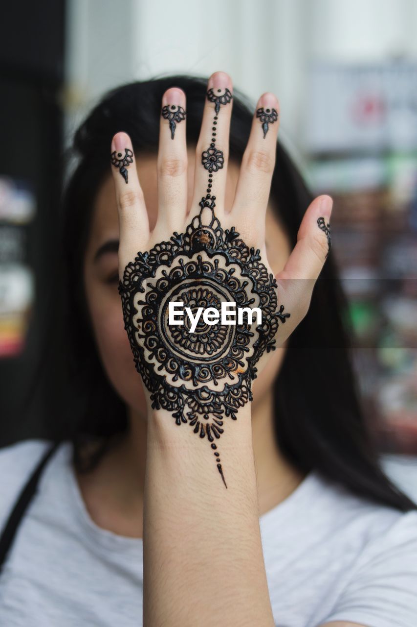 Close-up of woman showing henna tattoo on hand
