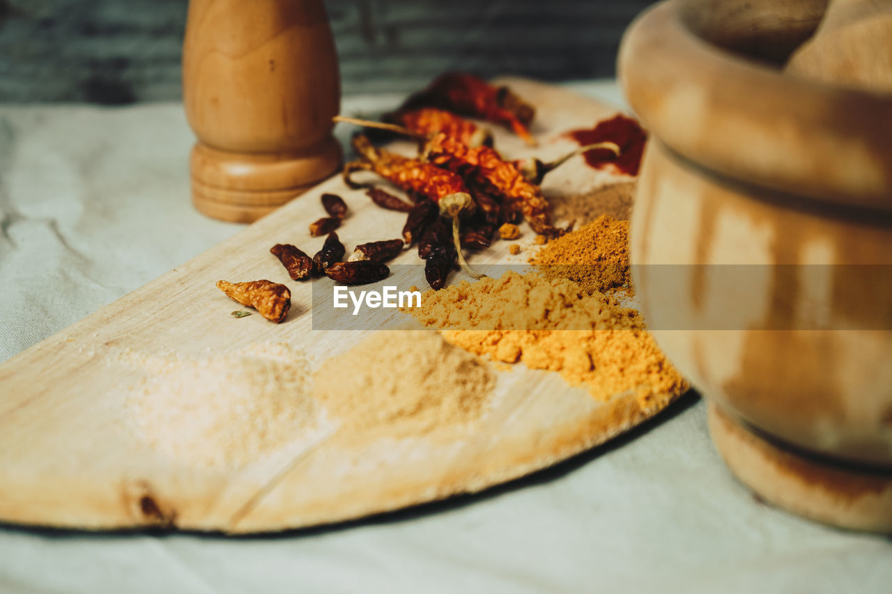 Spices by mortar and pestle on table