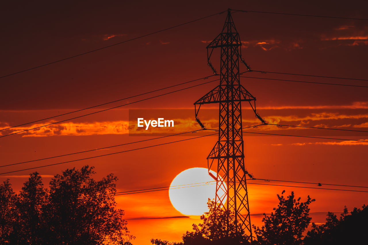 LOW ANGLE VIEW OF SILHOUETTE ELECTRICITY PYLON AGAINST ORANGE SKY