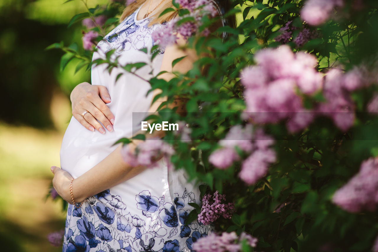 Close-up of pregnant woman standing by plants