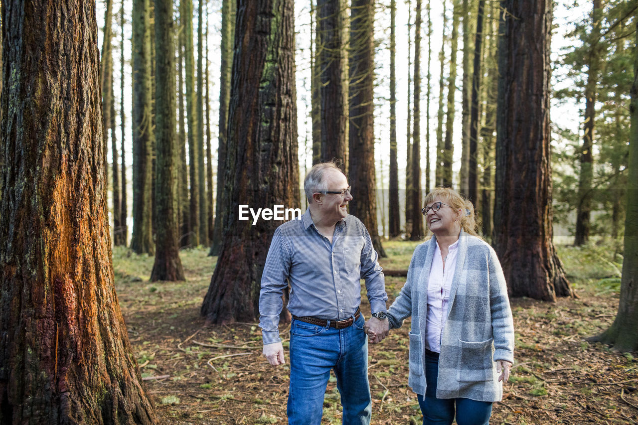 Retired romantic couple walking through the forest.