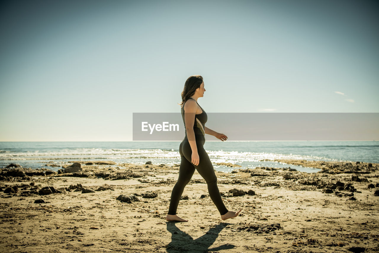 Girl walking on the beach in sportswear